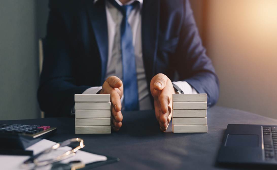 A person in a suit and tie holding a stack of white rectangular objects
AI-generated content may be incorrect.